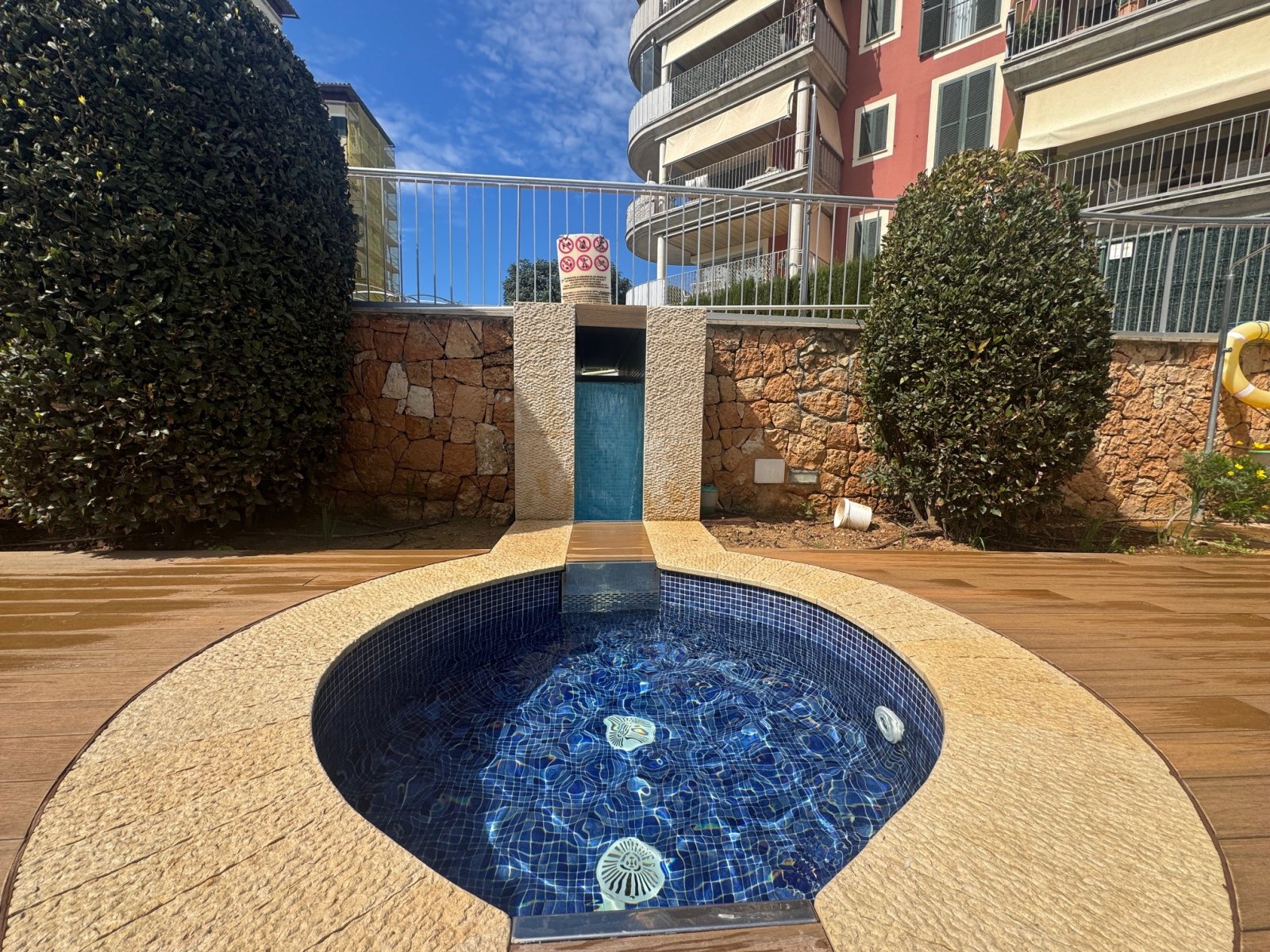 Patio privado con elegante piscina y cerramiento de piedra de alta calidad