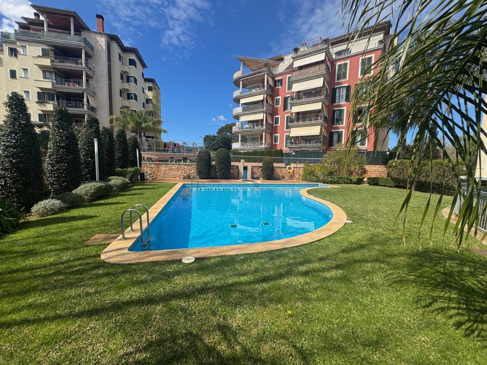 Piscina comunitaria con gran zona verde y concepto de ocio moderno