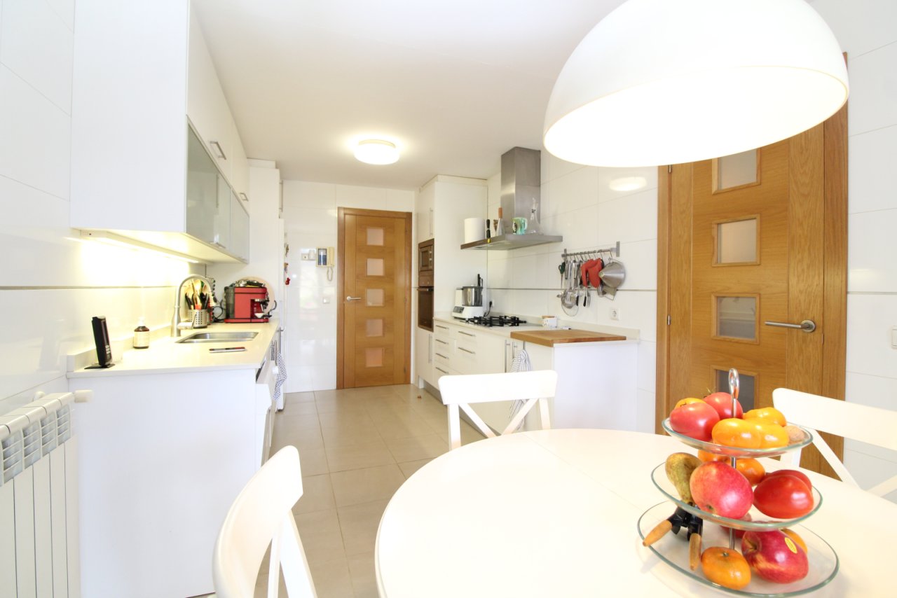 Cocina moderna con comedor central y distribución inteligente de funciones