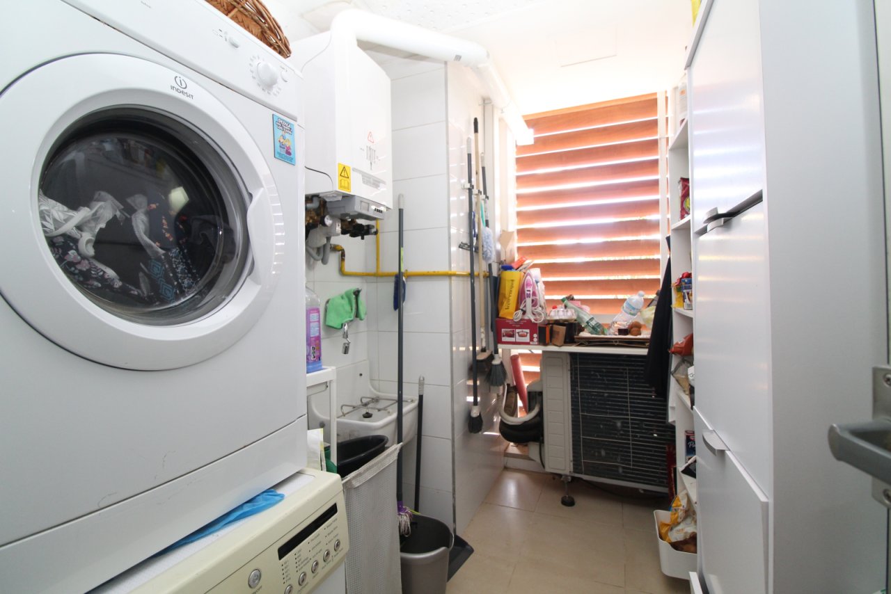 Área práctica de lavandería con electrodomésticos modernos y uso inteligente del espacio