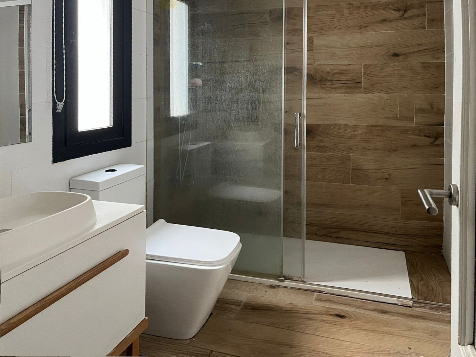 Baño moderno con ducha a ras de suelo y equipamiento sanitario de alta calidad