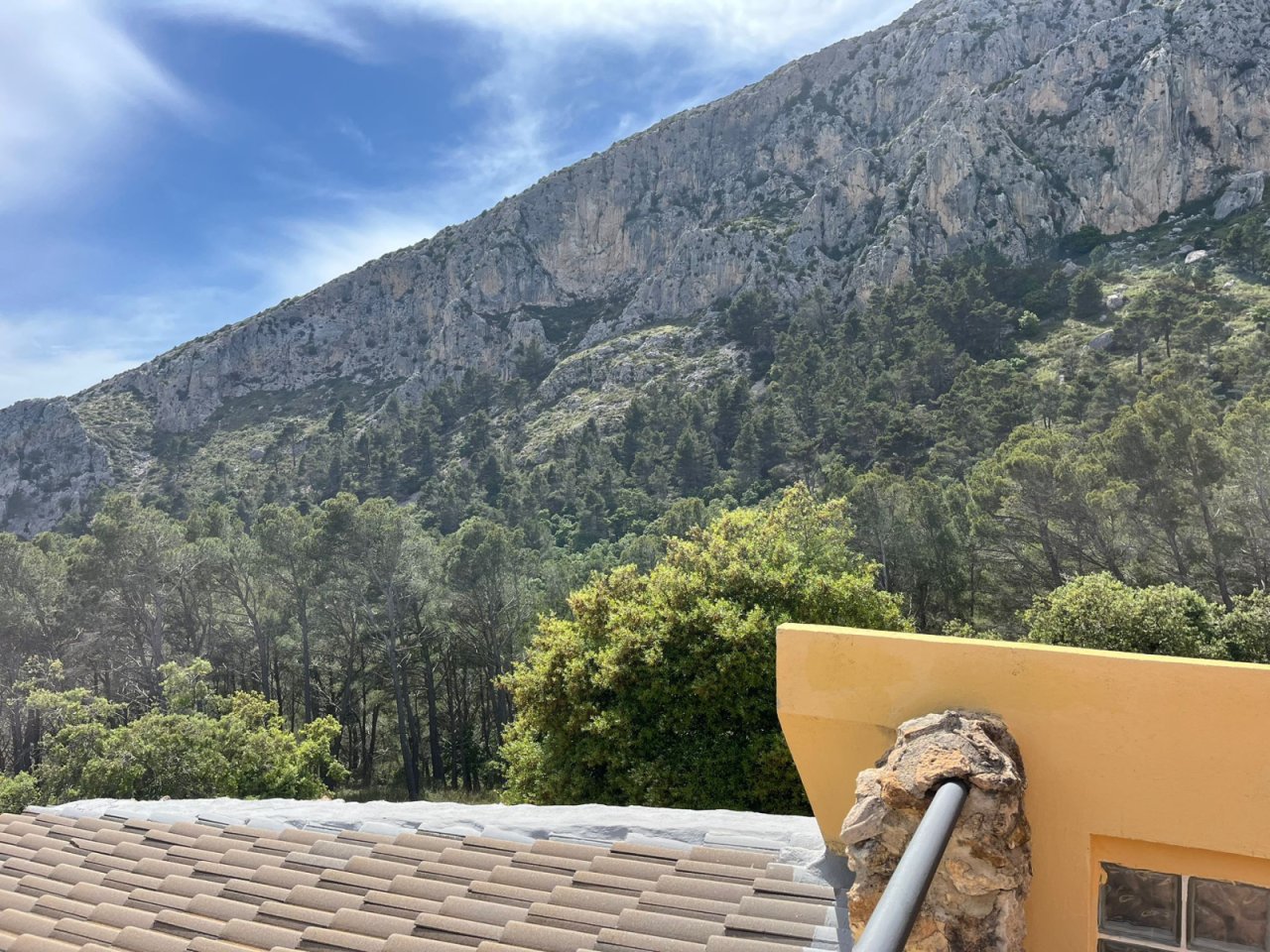 Terraza en la azotea con barandilla de piedra natural – Vista inalterable de la montaña sobre pendientes boscosas y macizos rocosos