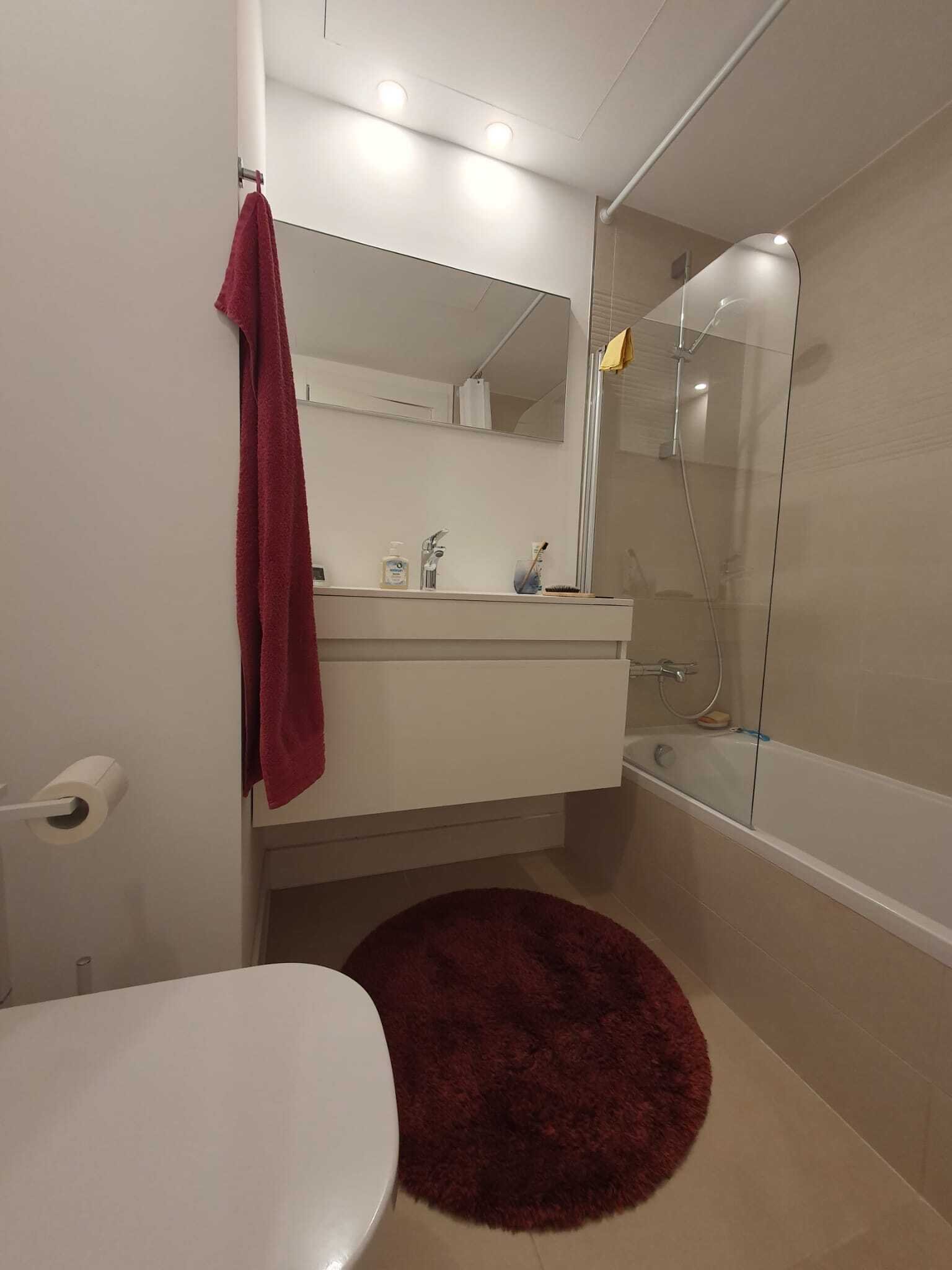 Baño moderno con ducha a nivel del suelo y espejo de gran tamaño