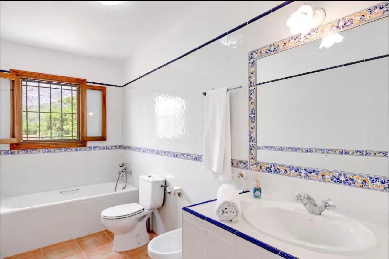 Baño luminoso con bañera, ducha y ventanas de madera de gran tamaño