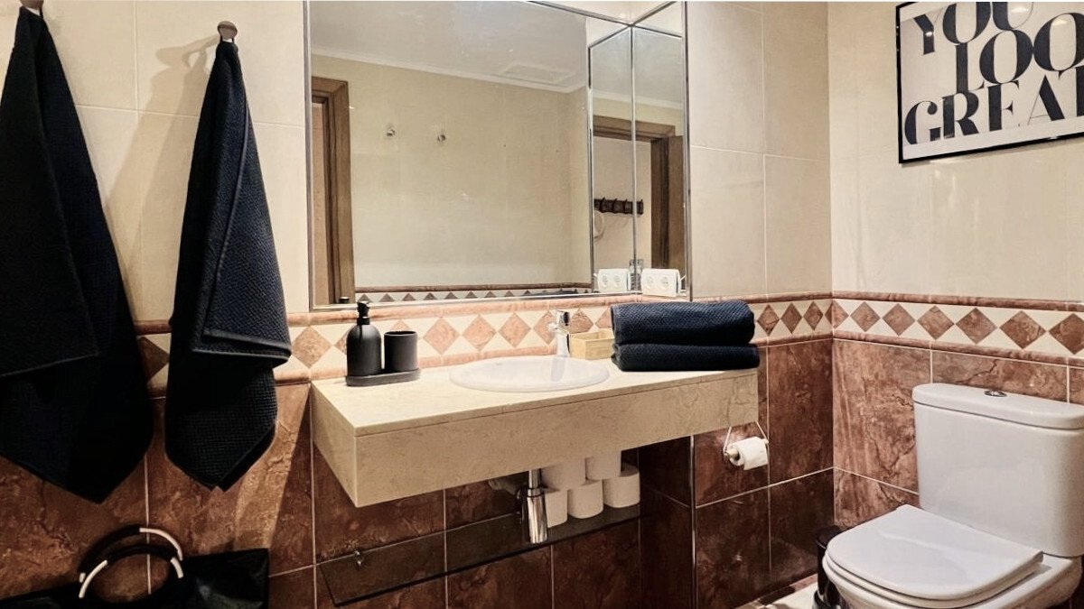 Baño elegante con espejo grande y equipamiento de alta calidad Baño elegante con espejo grande y equipamiento de alta calidad