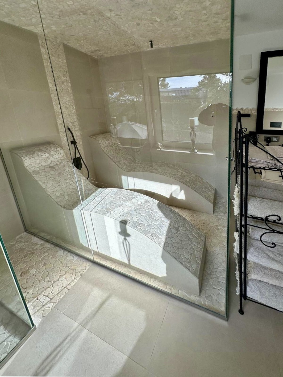 Baño lujoso con ducha a ras de suelo, bañera y ventanas panorámicas – oasis de bienestar con vistas