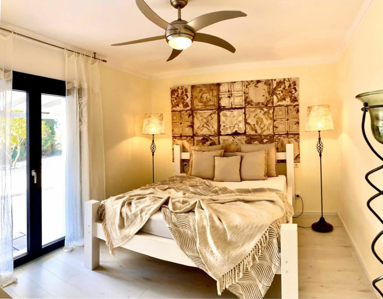 Dormitorio luminoso con ventilador de techo y acceso directo a la terraza