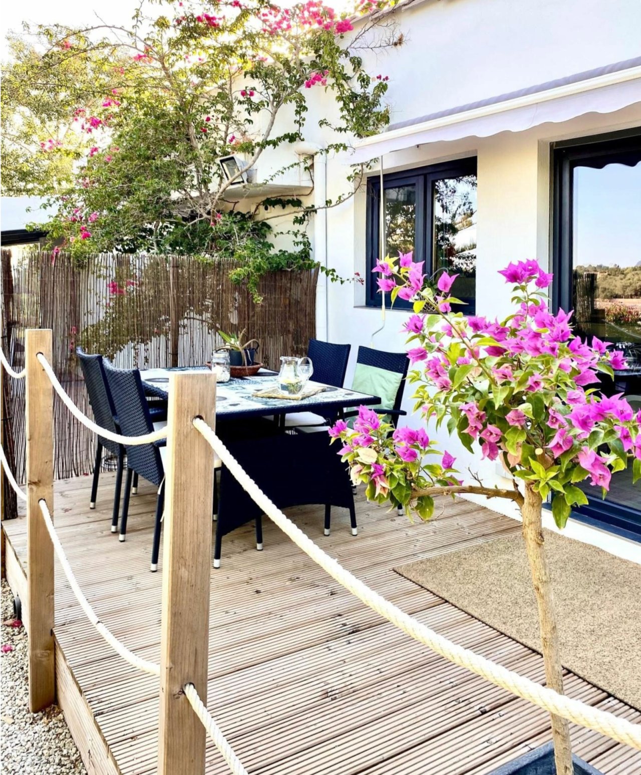 Área de terraza con tarima de madera de alta calidad, protección contra el viento y conexión directa con la zona de estar