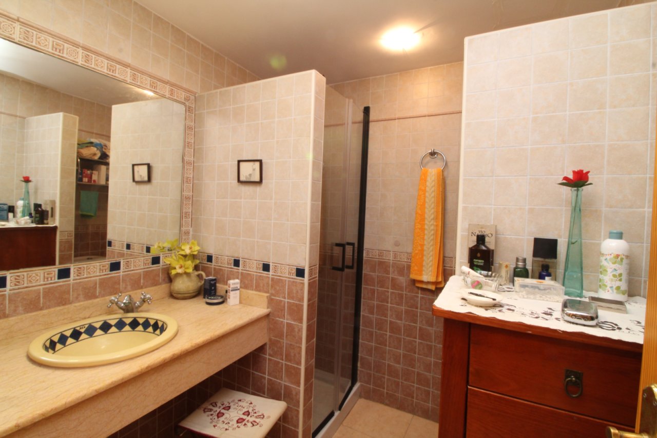 Baño elegante con ducha separada y doble lavabo