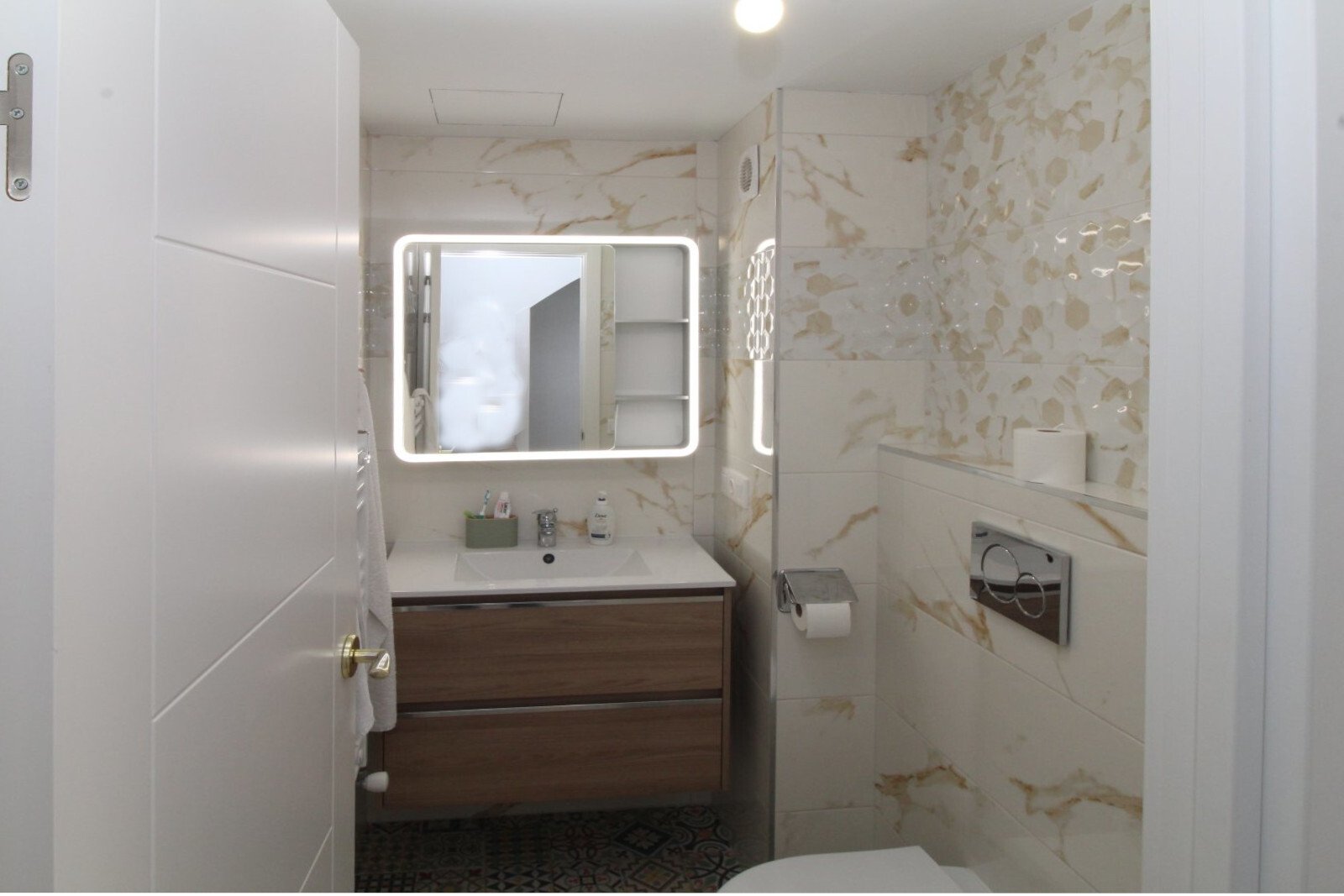Baño moderno con sistema de espejo LED y ducha a ras de suelo