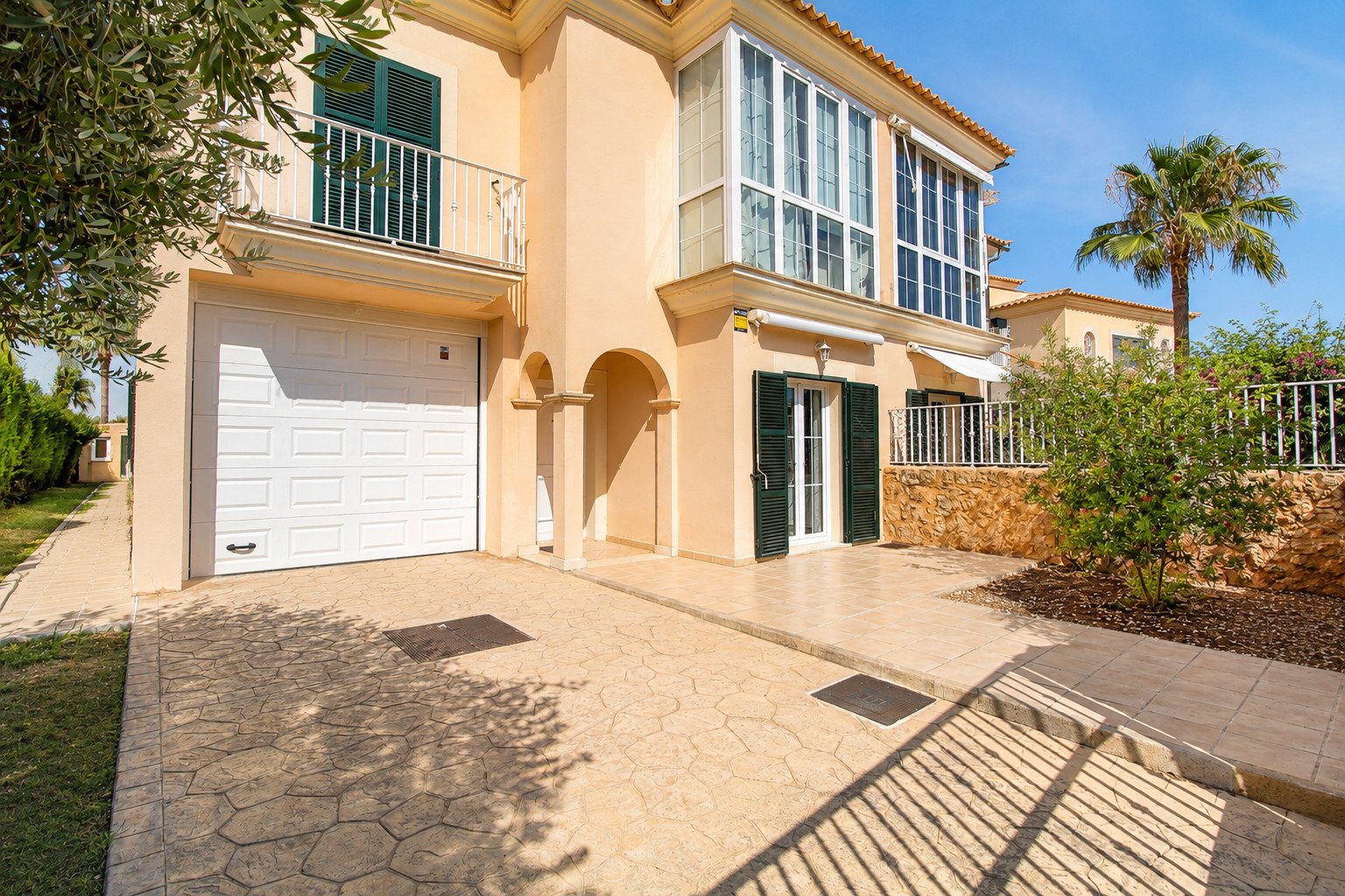 Entrada pavimentada con acceso directo a la cochera y una elegante zona de entrada a la casa Entrada pavimentada con acceso directo a la cochera y una elegante zona de entrada a la casa