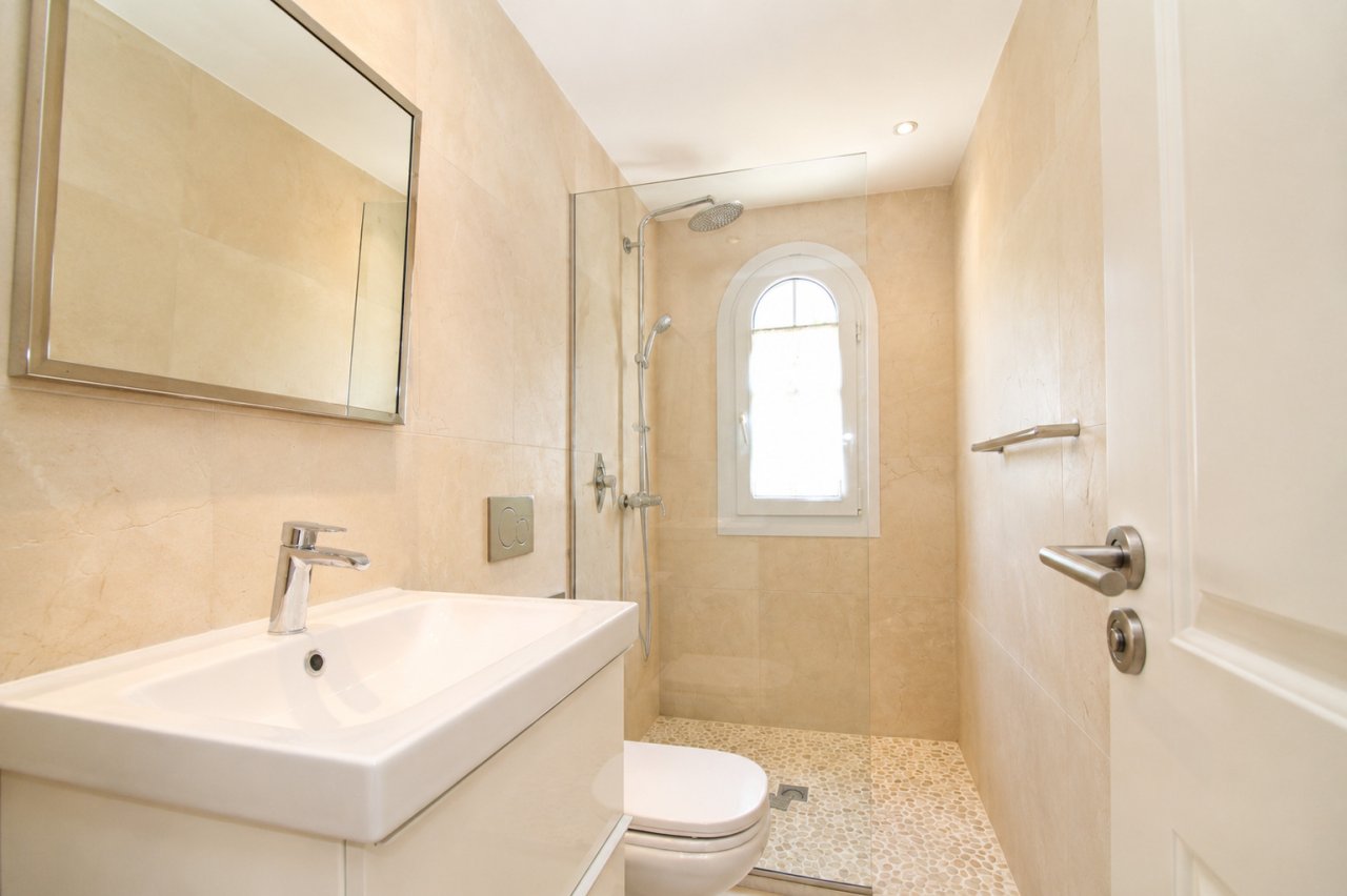 Baño moderno con ducha a ras de suelo, iluminación natural y accesorios sanitarios de alta calidad Baño moderno con ducha a ras de suelo, iluminación natural y accesorios sanitarios de alta calidad