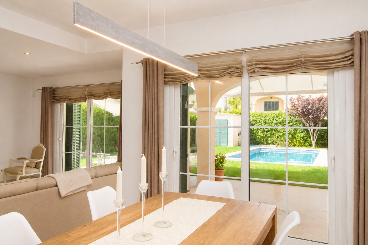Área de comedor con puertas correderas de vidrio de gran tamaño y iluminación LED integrada en el techo Área de comedor con puertas correderas de vidrio de gran tamaño y iluminación LED integrada en el techo
