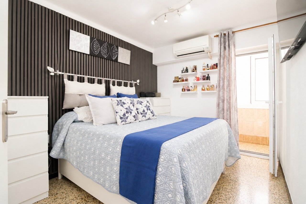 Habitación cómoda con aire acondicionado split y estanterías empotradas prácticas