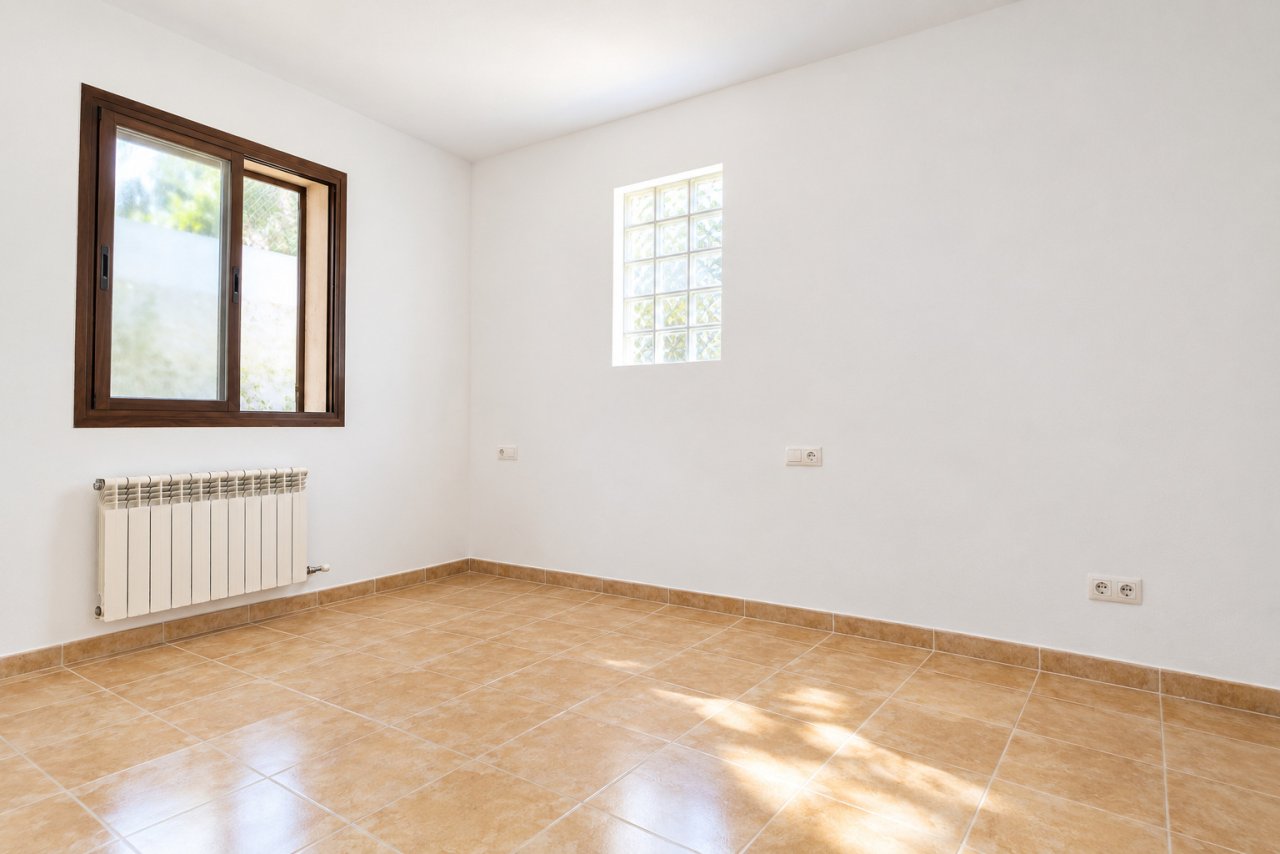 Habitación luminosa con distribución funcional de ventanas y solución práctica para el radiador Habitación luminosa con distribución funcional de ventanas y solución práctica para el radiador