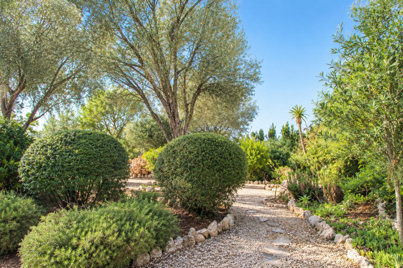 Jardín privado encantado con senderos empedrados y vegetación mediterránea