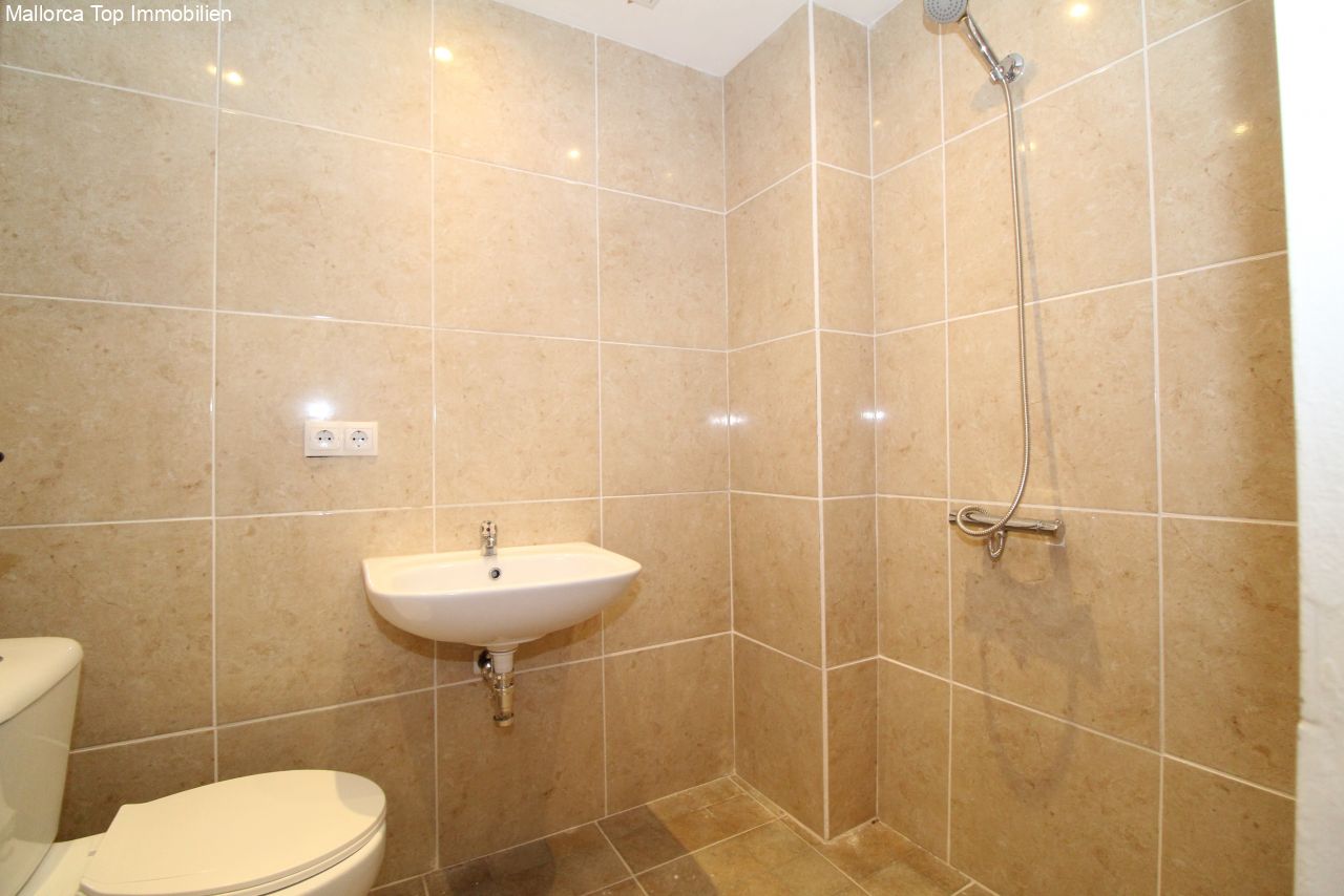 Baño moderno con ducha a nivel del suelo y acabado de azulejos de alta calidad, con una cómoda cabina de ducha y equipamiento práctico.