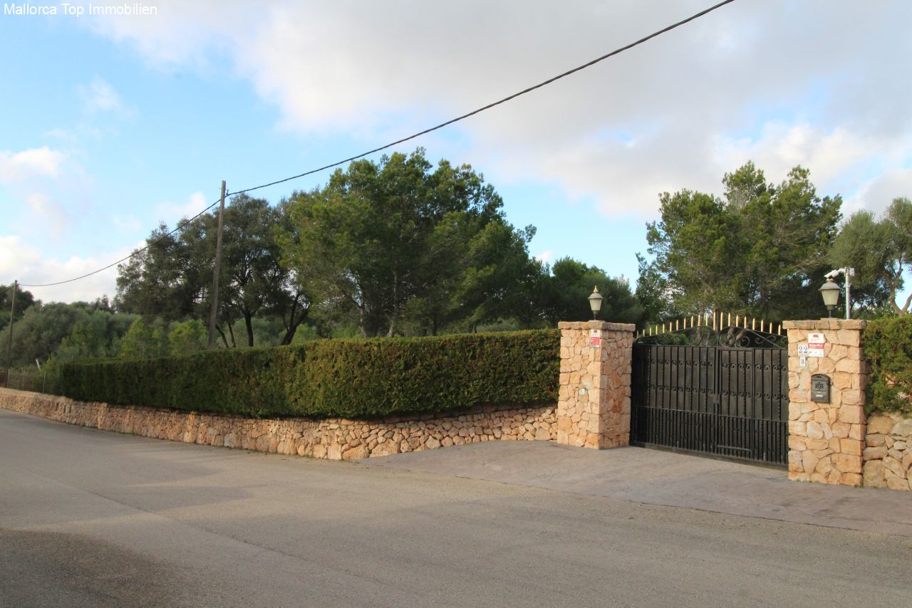 Entrada segura con pilares de piedra natural macizos y puerta automática Entrada segura con pilares de piedra natural macizos y puerta automática