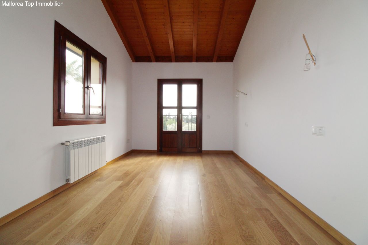 Habitación luminosa con techo de vigas de madera con carácter, sistema de calefacción y puertas francesas de cristal al balcón