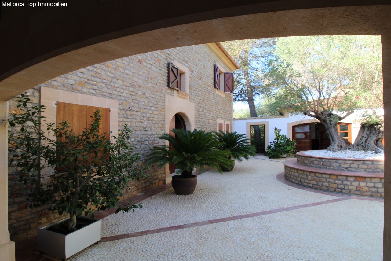 Patio cubierto con elegante estructura de arcos y muros de piedra natural auténtica Patio cubierto con elegante estructura de arcos y muros de piedra natural auténtica