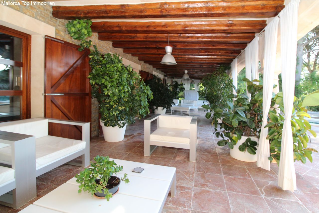 Terraza lounge cubierta con vigas de madera rústicas y un concepto de columnas bien pensado Terraza lounge cubierta con vigas de madera rústicas y un concepto de columnas bien pensado