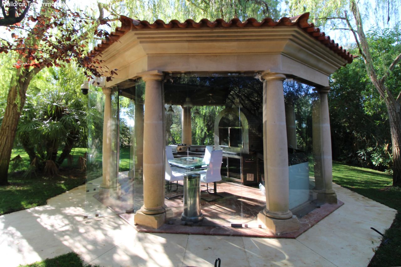 Elegante pérgola con arquitectura de columnas y cocina exterior integrada Elegante pérgola con arquitectura de columnas y cocina exterior integrada
