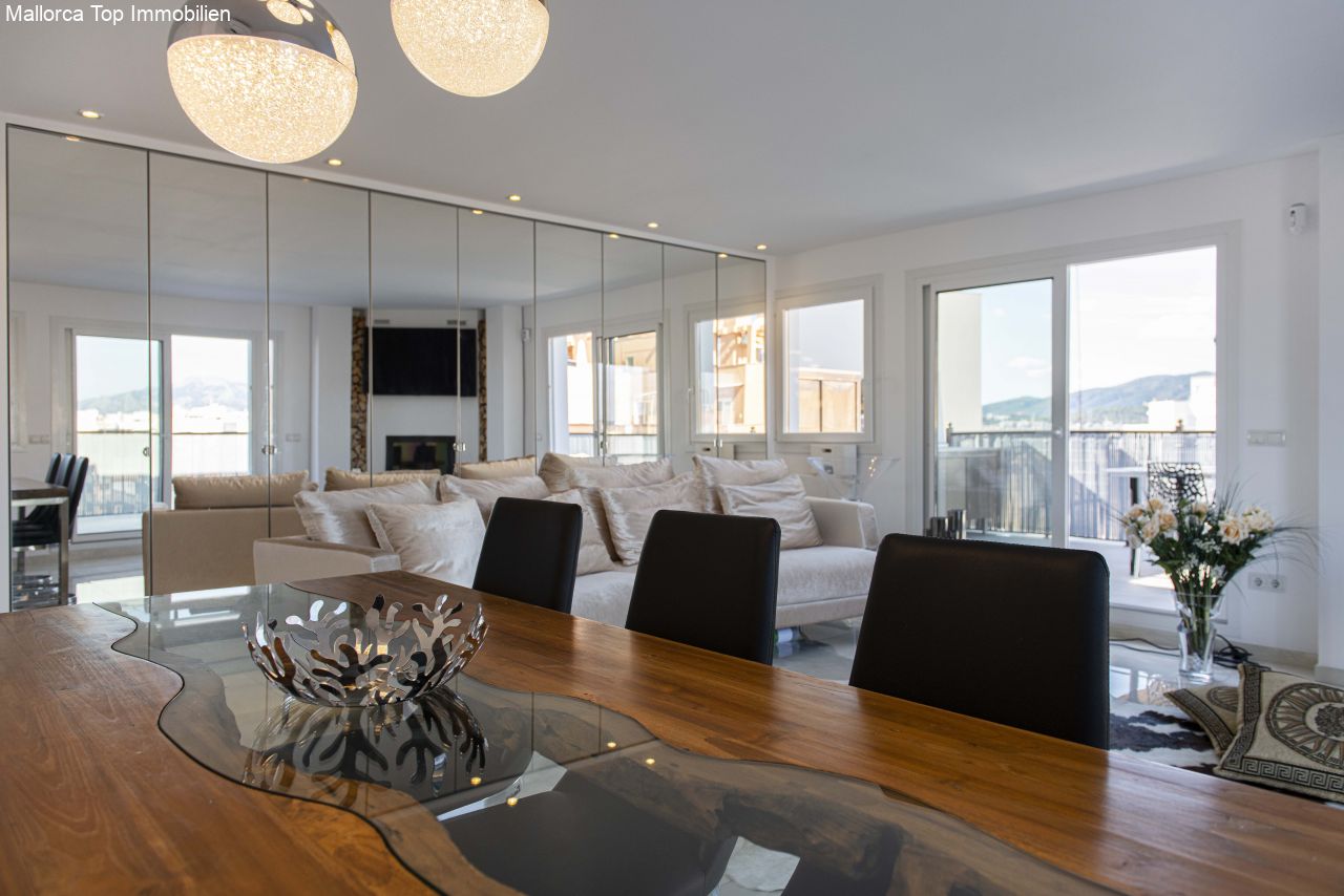 Elegante zona de estar con paredes de cristal de altura completa y chimenea