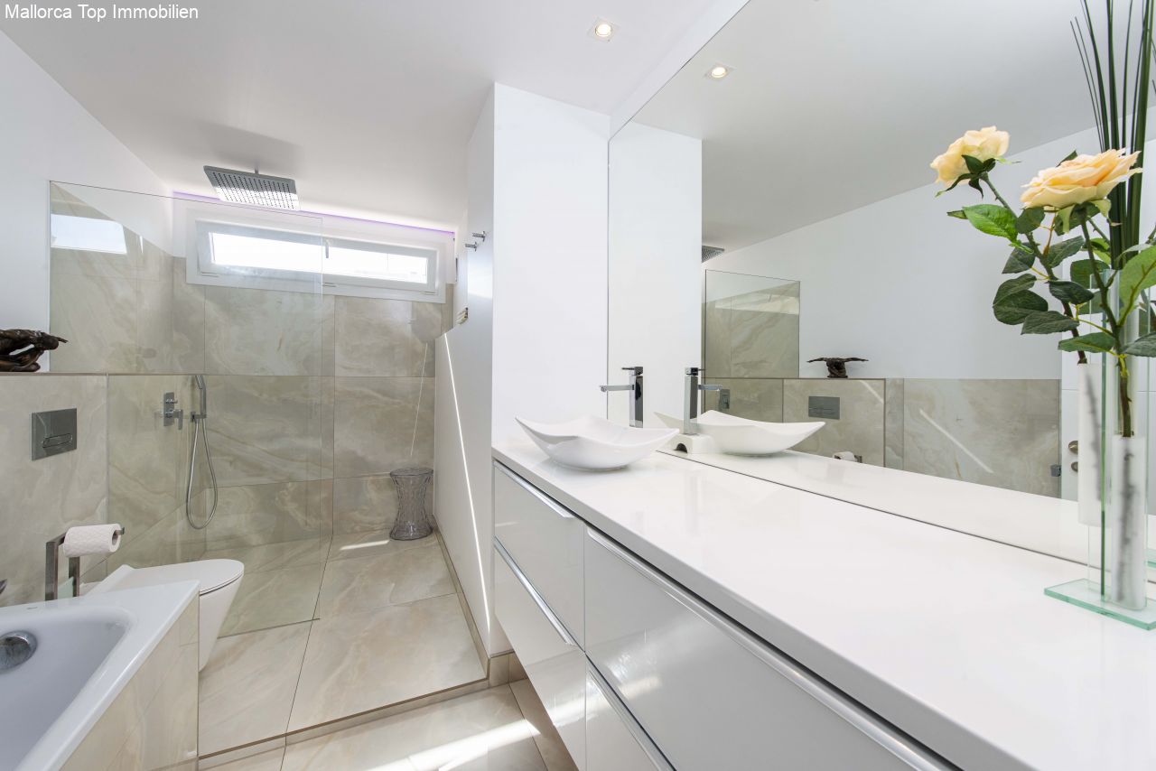 Baño lujoso con doble lavabo y ducha a ras de suelo