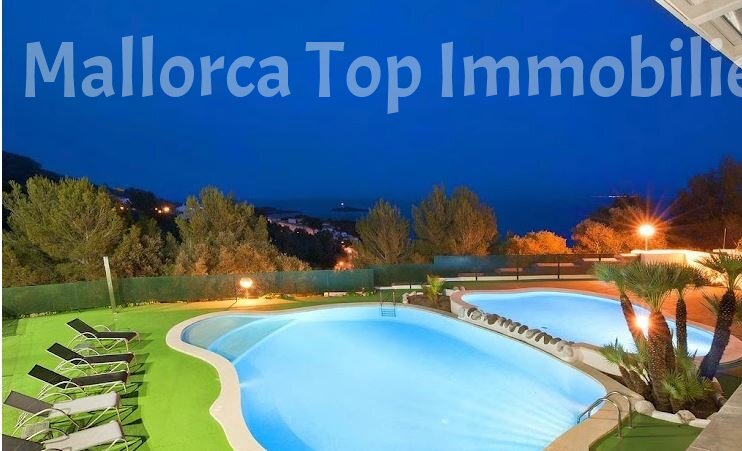 Piscina iluminada con zona de descanso y vistas al mar – Perfecta para tardes relajantes