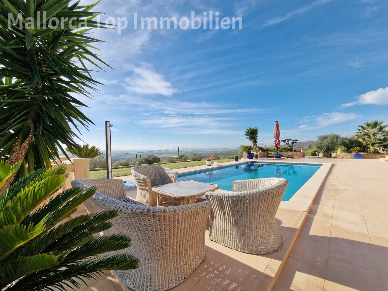 Área de piscina con amplia terraza soleada y vista panorámica