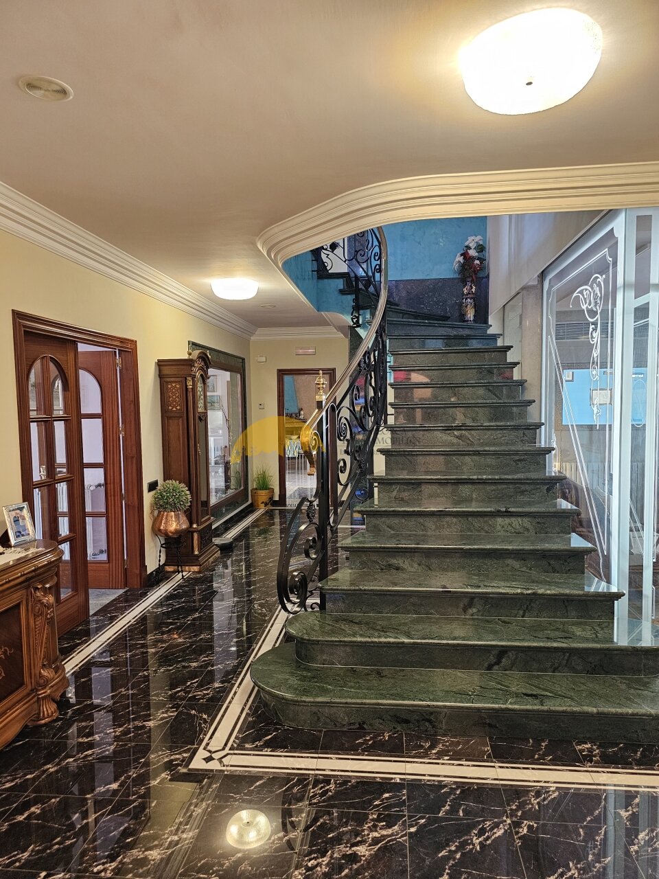 Vestíbulo espectacular con escalera de mármol curva y barandilla de hierro forjado artística, un punto culminante arquitectónico con una impresionante sensación de espacio. Vestíbulo espectacular con escalera de mármol curva y barandilla de hierro forjado artística, un punto culminante arquitectónico con una impresionante sensación de espacio.