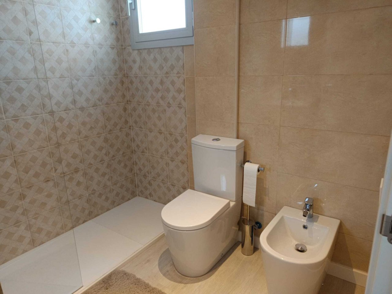 Baño moderno con ducha a nivel del suelo, inodoro separado y elegante diseño de azulejos Baño moderno con ducha a nivel del suelo, inodoro separado y elegante diseño de azulejos