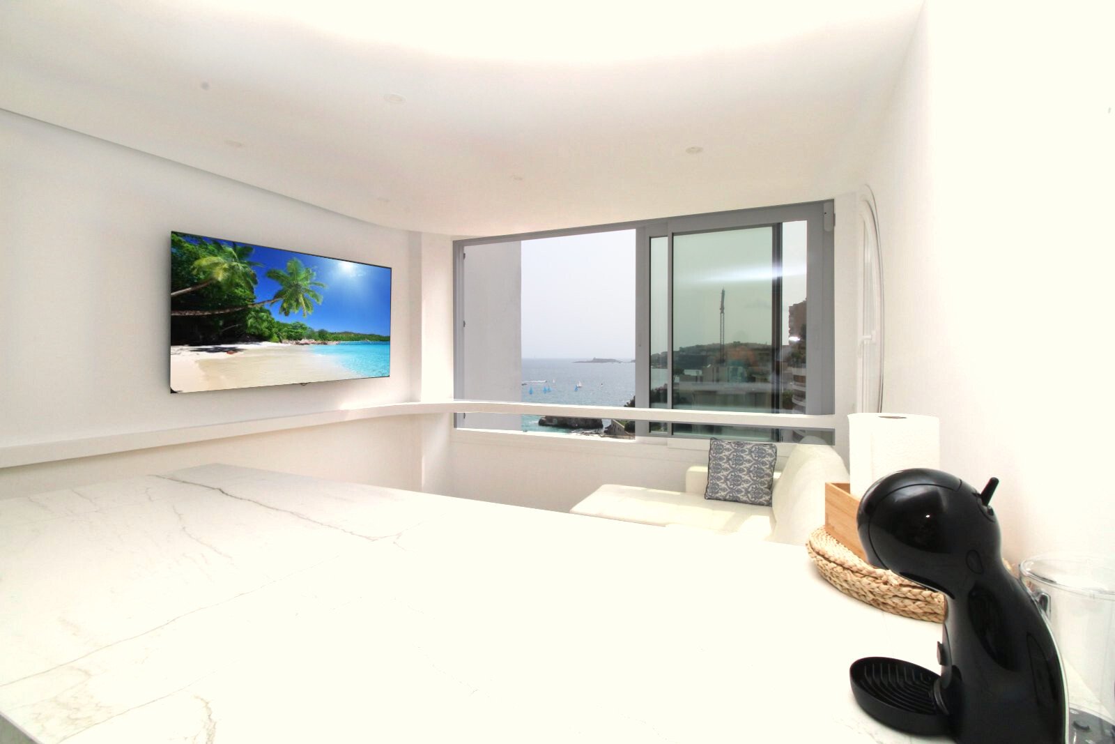 Área de estar con ventanales de piso a techo y vistas ininterrumpidas al mar – La arquitectura moderna se encuentra con la vista panorámica