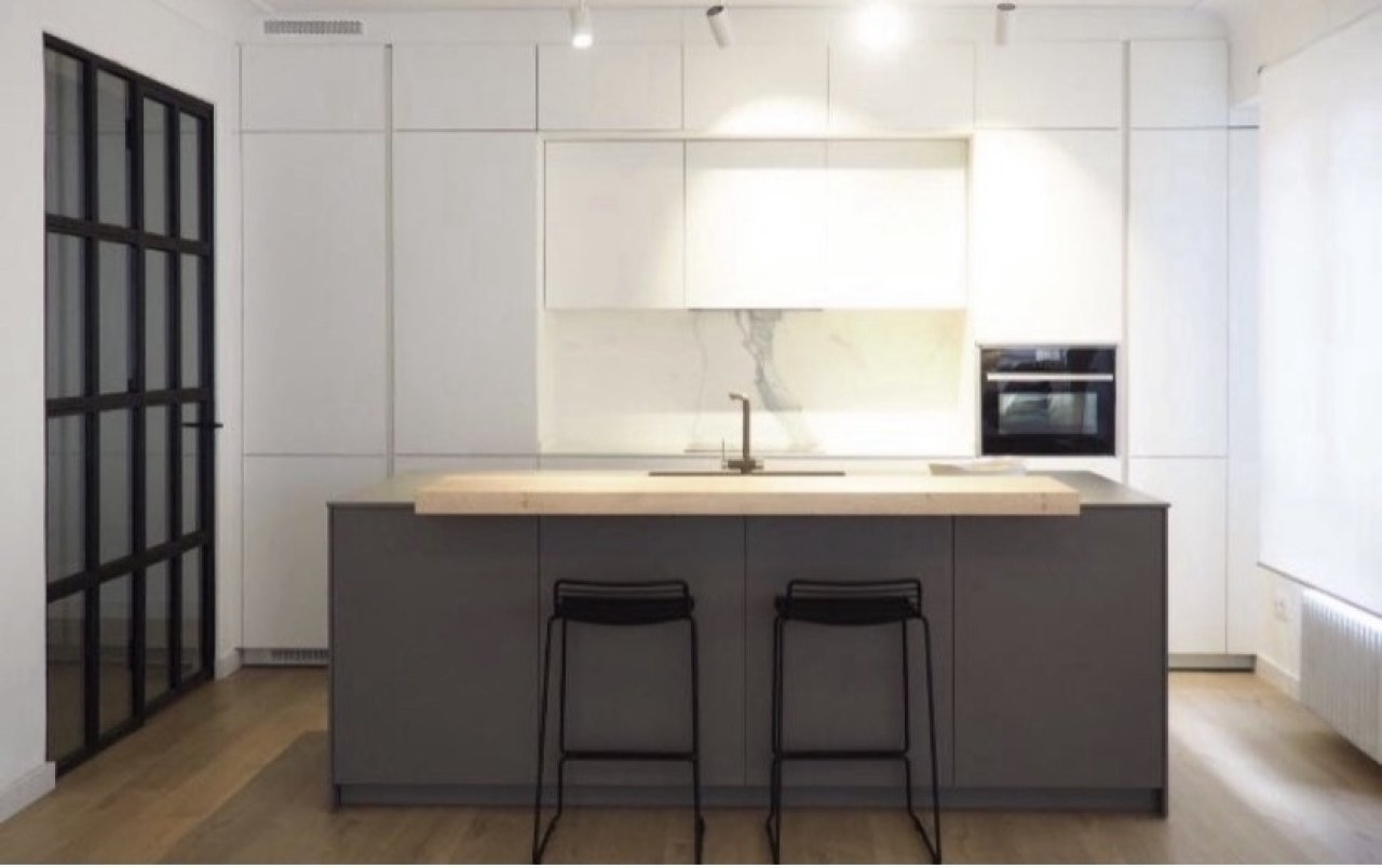 Cocina moderna con isla central, electrodomésticos integrados de alta calidad y conexión abierta del espacio Cocina moderna con isla central, electrodomésticos integrados de alta calidad y conexión abierta del espacio