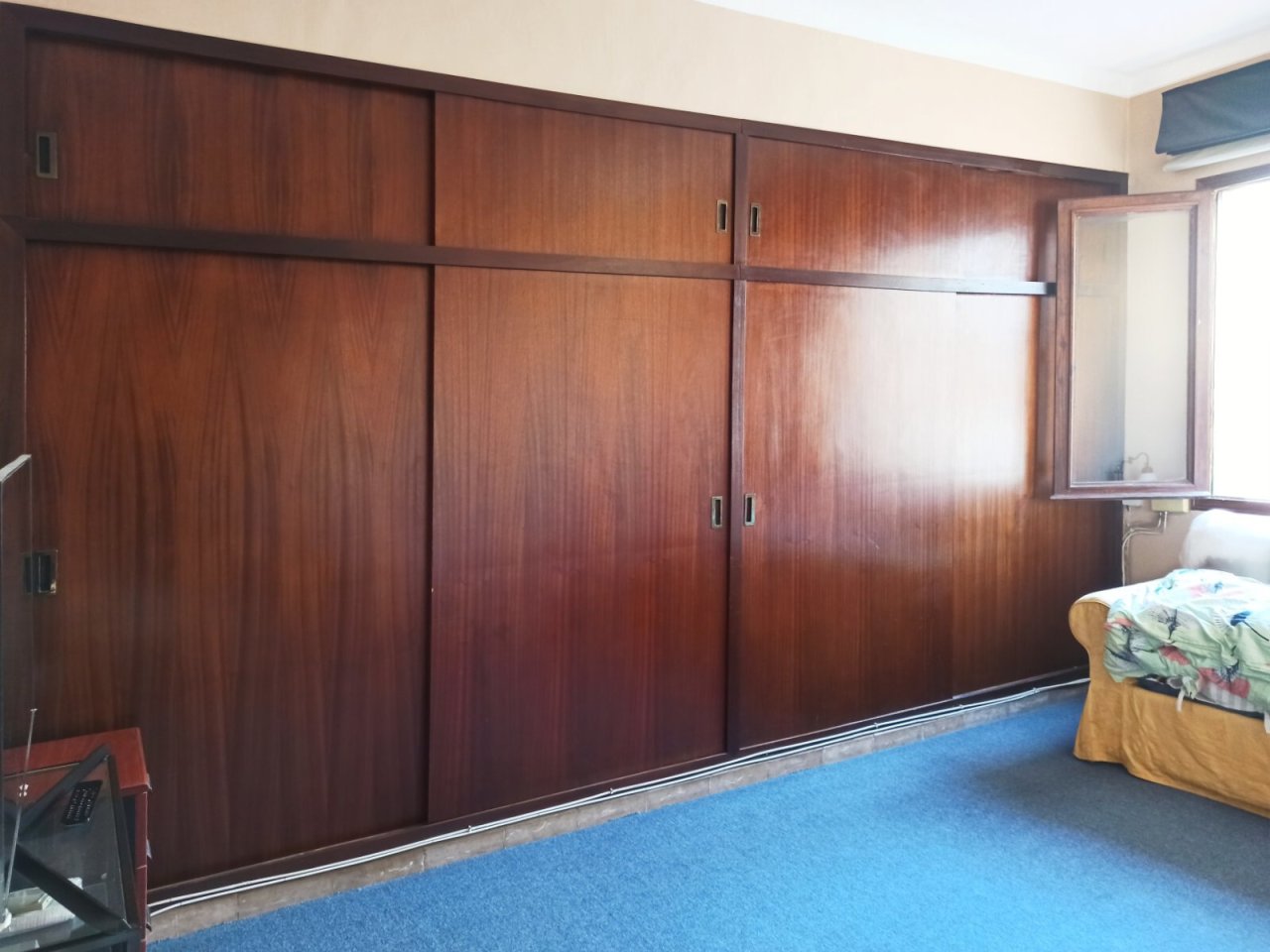 Dormitorio con amplio armario empotrado y solución óptima de almacenamiento