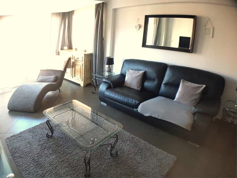 Salón con grandes ventanales y soporte para TV