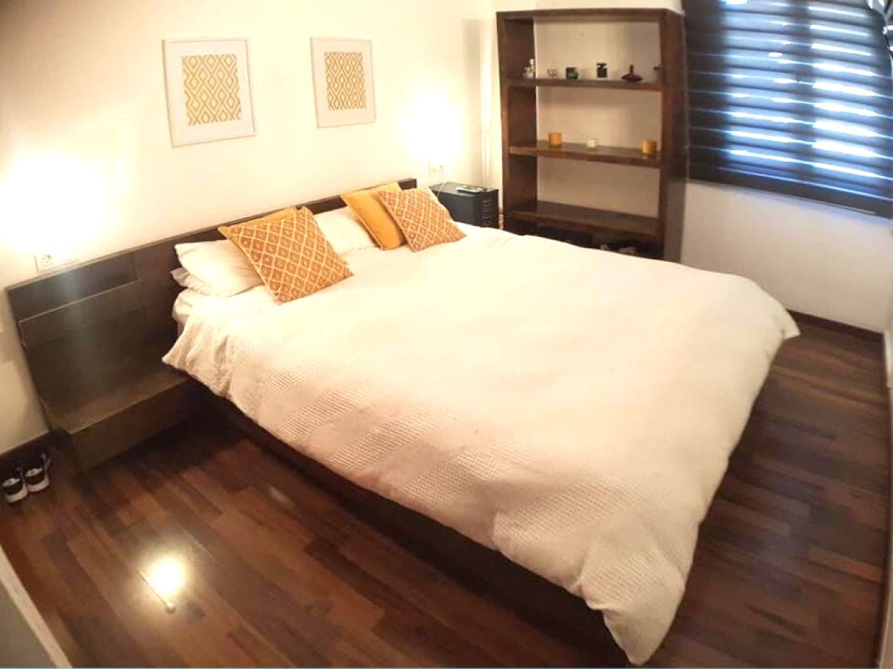 Dormitorio con suelo de parquet y almacenamiento integrado