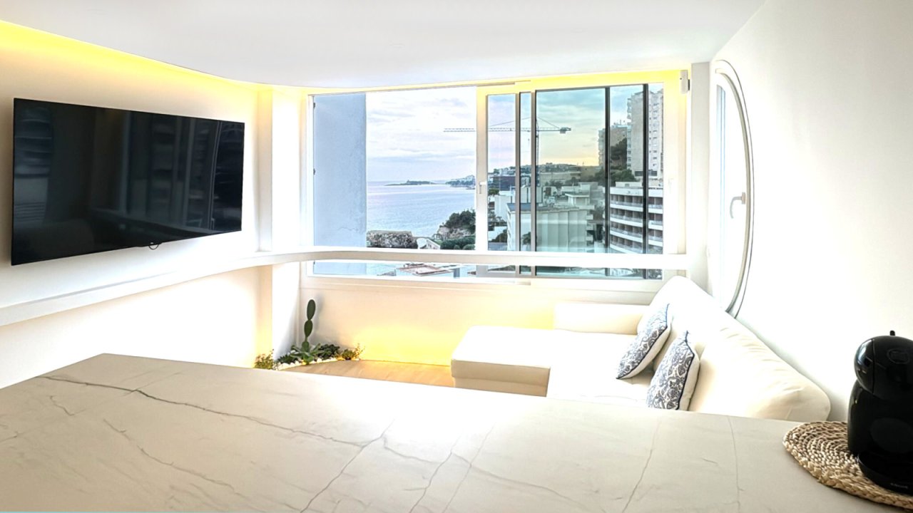 Salón con vistas al mar – Ventanas de piso a techo y conceptos de iluminación inteligente