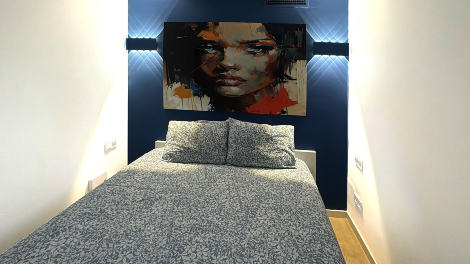 Dormitorio con iluminación indirecta en la pared y diseño funcional de nicho