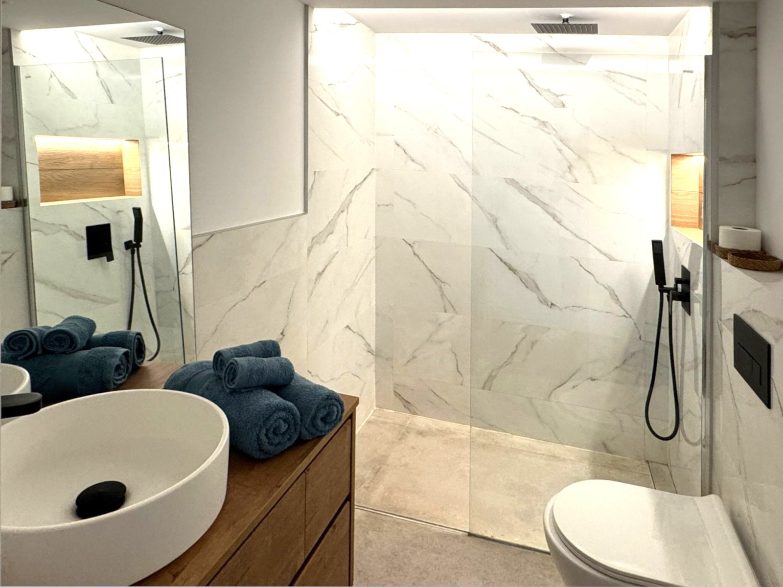 Baño lujoso con ducha a ras de suelo y diseño accesible – elegancia en mármol que combina con un estilo moderno