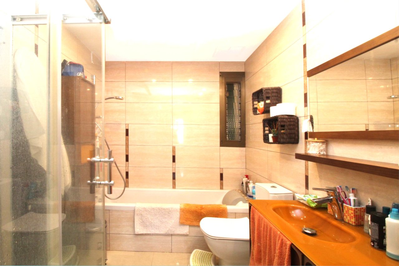 Baño moderno con ducha a nivel del suelo e integración inteligente de almacenamiento