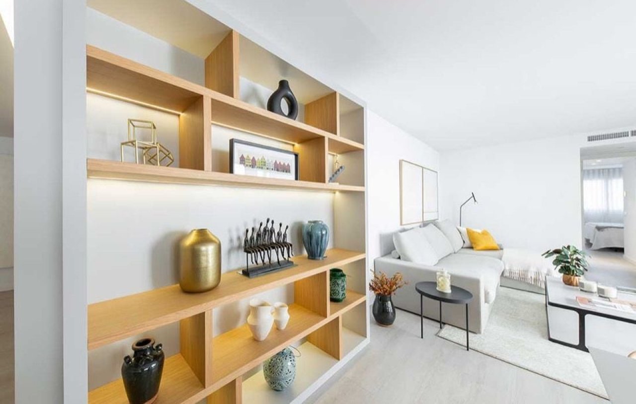 Sala de estar moderna con estanterías empotradas a medida y iluminación indirecta Sala de estar moderna con estanterías empotradas a medida y iluminación indirecta