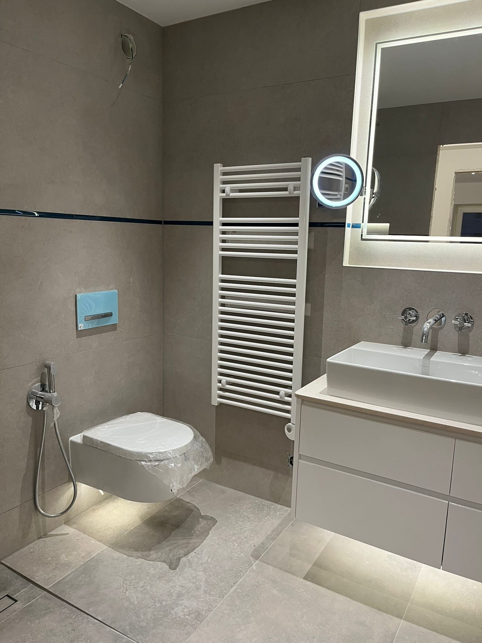 Baño moderno con ducha a ras de suelo, toallero calefactable y prácticas nichos en la pared Baño moderno con ducha a ras de suelo, toallero calefactable y prácticas nichos en la pared