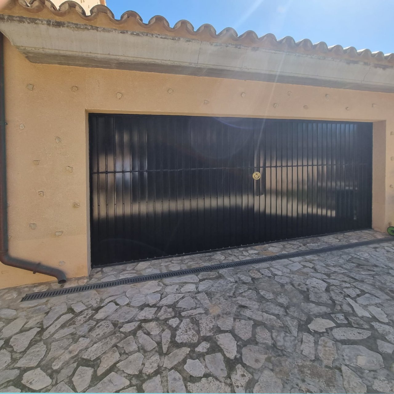 Acceso seguro con una robusta verja de metal y una zona de entrada pavimentada Acceso seguro con una robusta verja de metal y una zona de entrada pavimentada