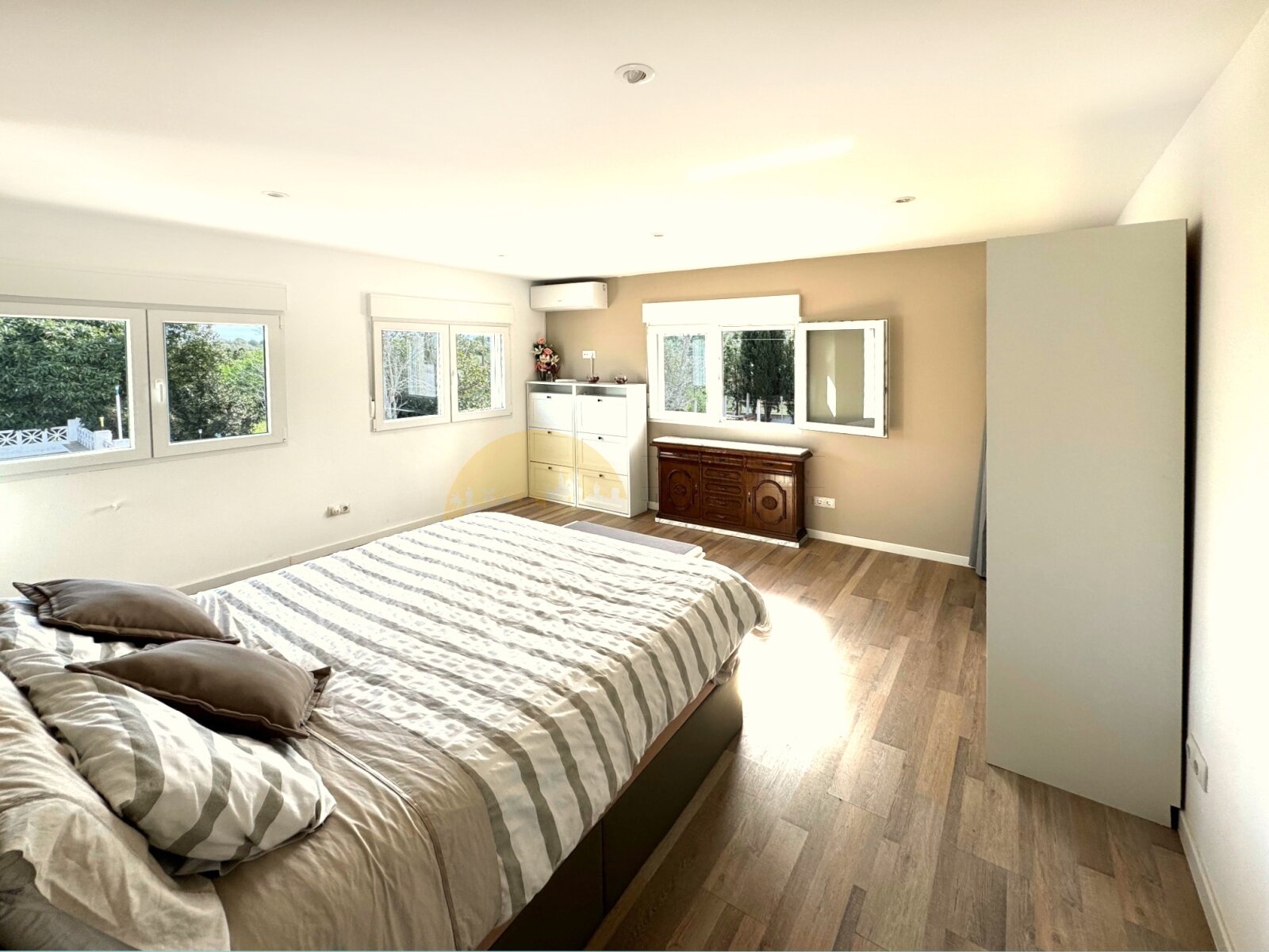 Dormitorio luminoso con ventanas grandes, múltiples opciones de almacenamiento y distribución óptima del espacio Dormitorio luminoso con ventanas grandes, múltiples opciones de almacenamiento y distribución óptima del espacio
