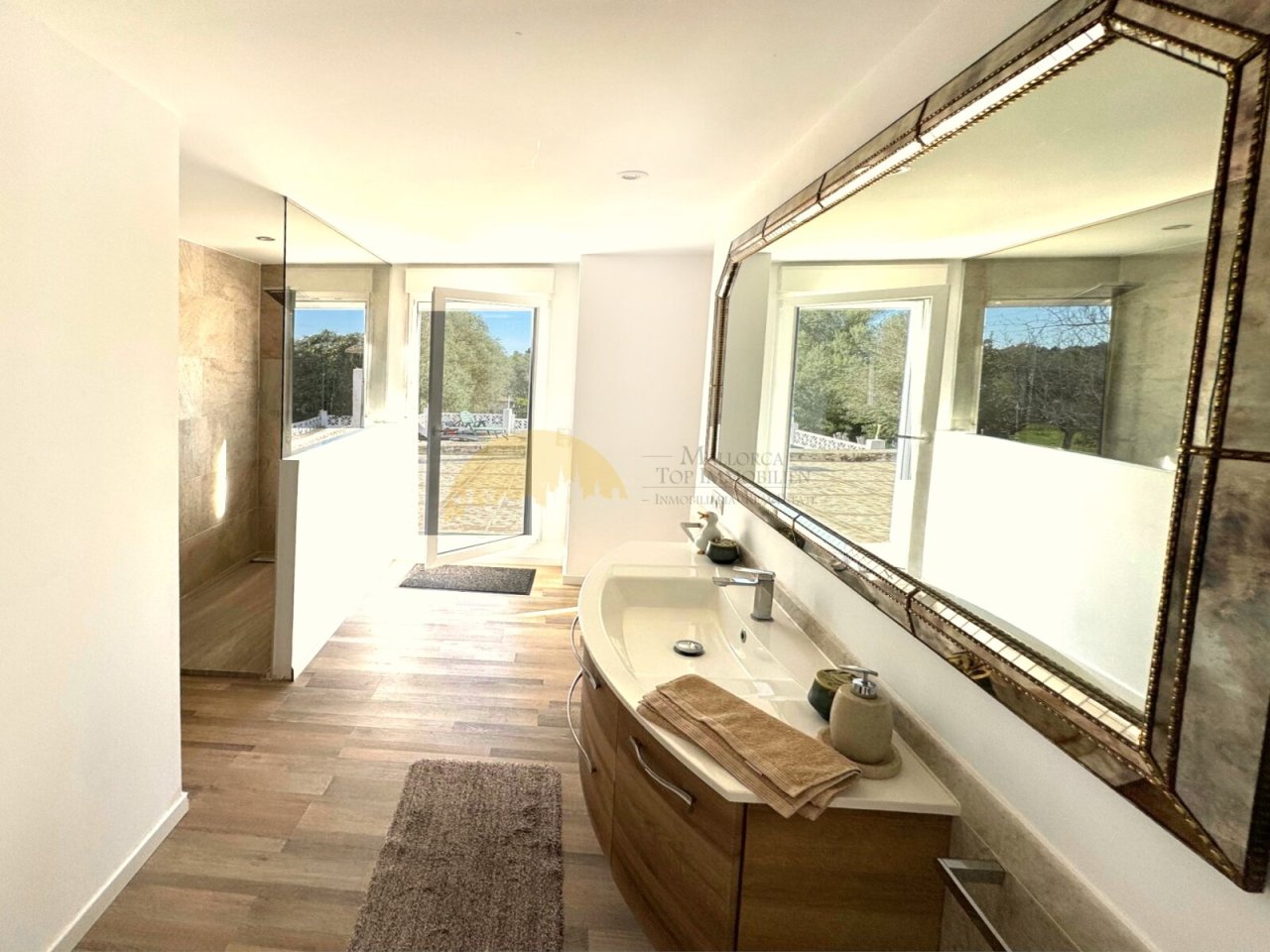 Baño principal lujoso con bañera independiente, ducha a ras de suelo y vista panorámica de la naturaleza Baño principal lujoso con bañera independiente, ducha a ras de suelo y vista panorámica de la naturaleza