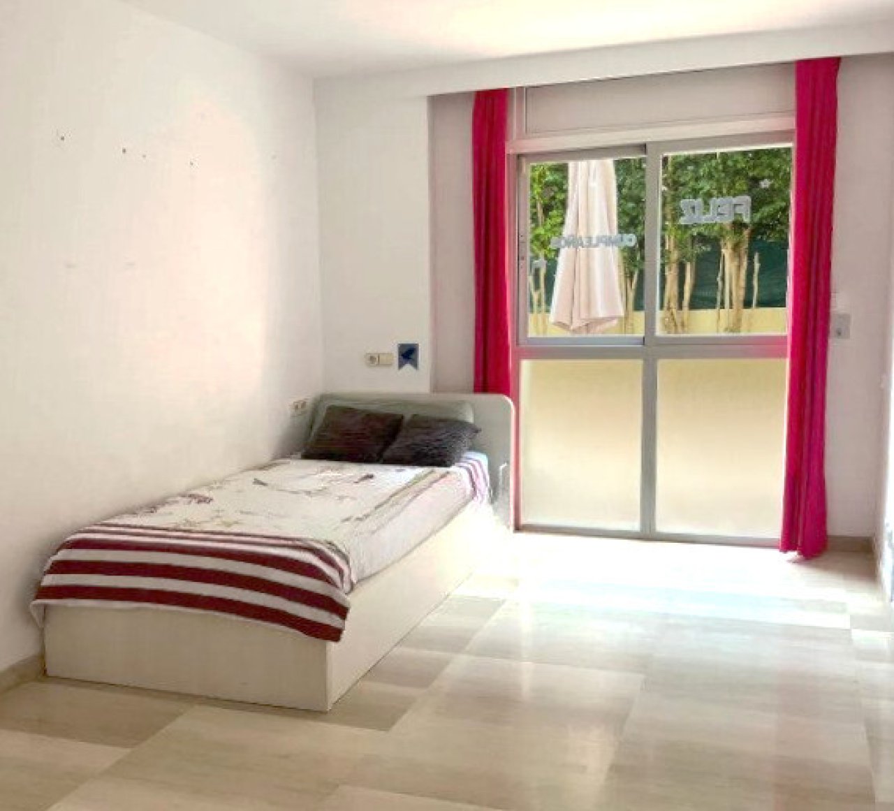 Habitación luminosa con grandes puertas correderas de cristal y vista directa al jardín Habitación luminosa con grandes puertas correderas de cristal y vista directa al jardín