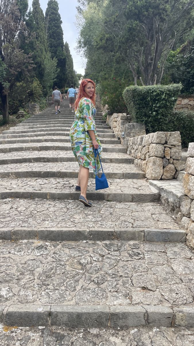 Ramona geht die historischen Treppen des Kalvarienbergs in Pollença hinauf.