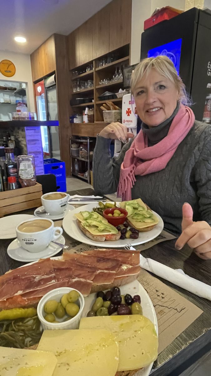 Claudia genießt eine Vorspeise mit Jamón und Käse – typische mallorquinische Spezialitäten an einem der schönsten Orte auf Mallorca