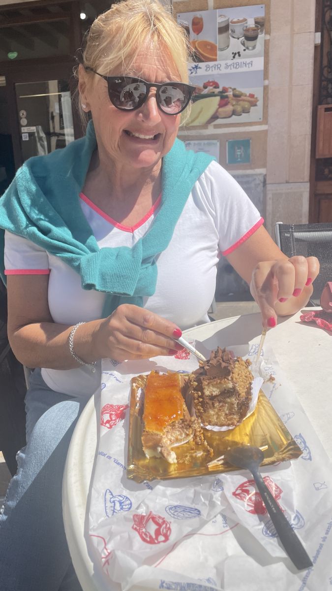Claudia genießt ein Stück Kuchen in einem Café – süße Momente an einem der schönsten Orte auf Mallorca
